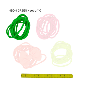 Set of neon green hair ties with a ruler for size reference on a white background
