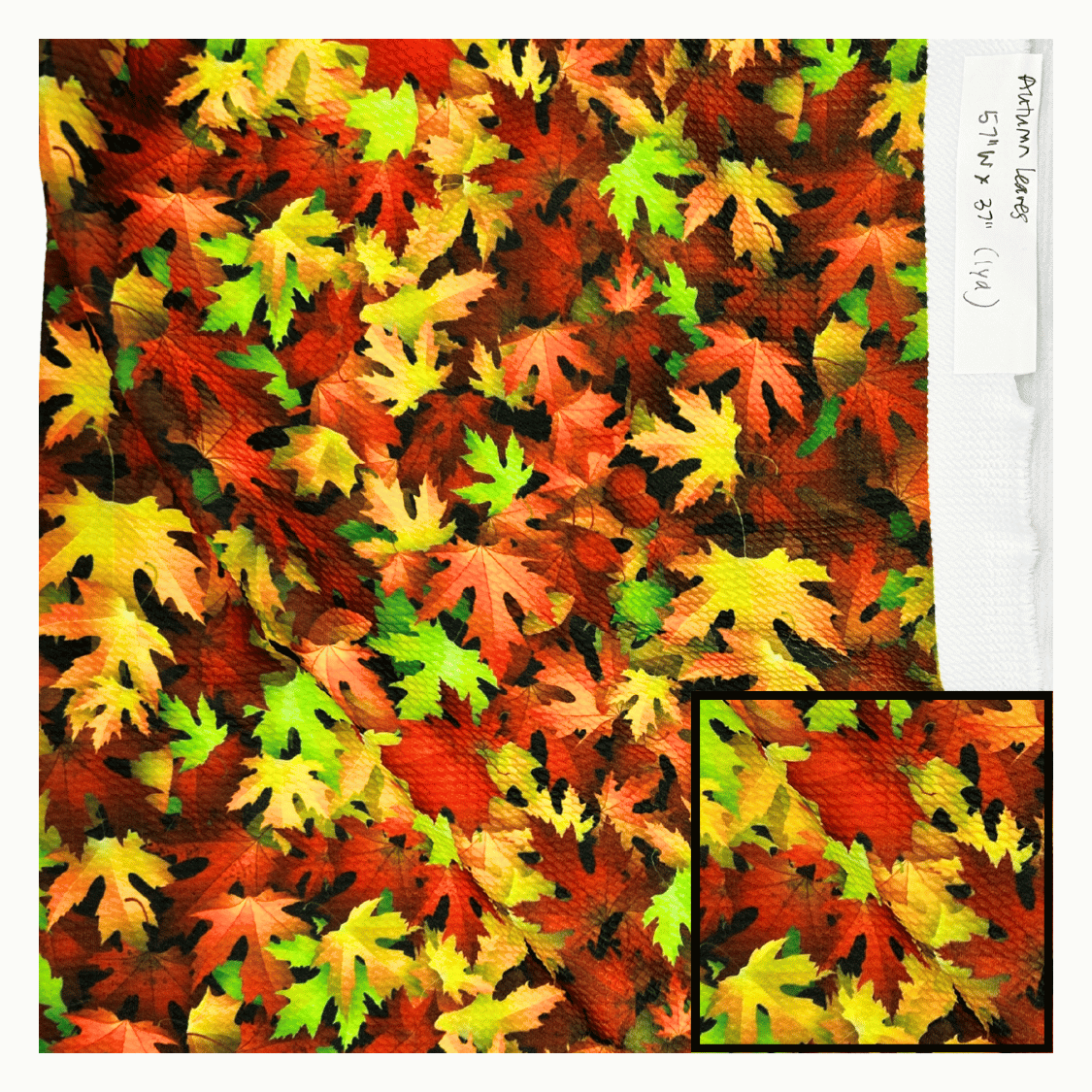 Fabric with autumn leaf pattern and a close-up inset showing texture details.