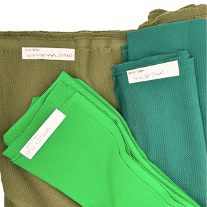 Three folded fabric swatches in olive green, forest green and kelly green.