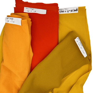Collection of fabric in variations of yellow and orange.